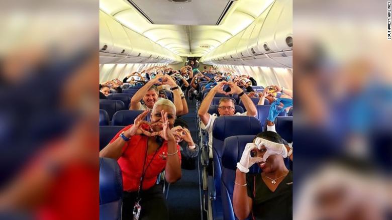 Εθελοντές γιατροί και νοσηλευτές μέσα σε καμπίνα αεροπλάνου σχηματίζουν καρδιά με τα δάχτυλά τους